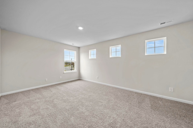 unfurnished room with visible vents, baseboards, and carpet flooring