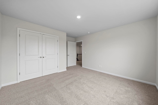 unfurnished bedroom with a closet, baseboards, and carpet floors