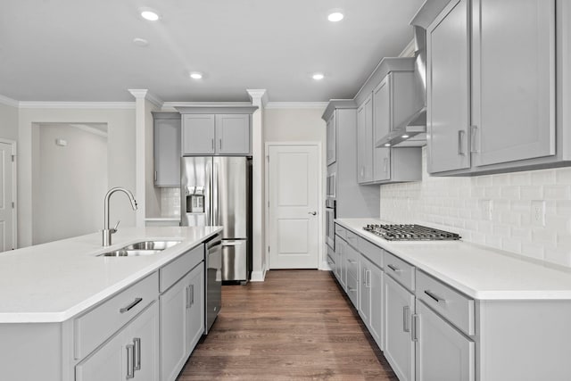 kitchen featuring dark wood-type flooring, ornamental molding, gray cabinets, a sink, and stainless steel appliances