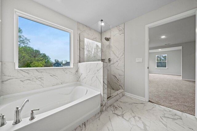 bathroom with a bath, a marble finish shower, marble finish floor, and baseboards