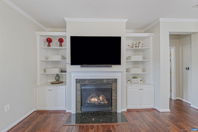 unfurnished living room featuring a premium fireplace, baseboards, wood finished floors, and crown molding