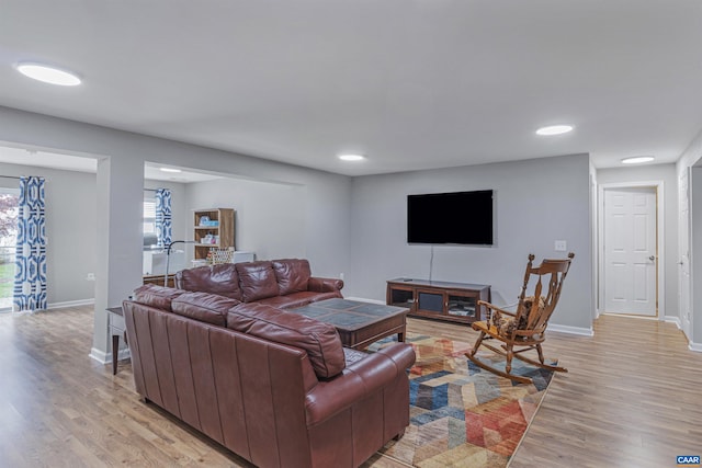 living area featuring recessed lighting, baseboards, and light wood-type flooring