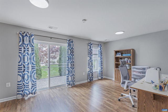 office area with visible vents, baseboards, and wood finished floors