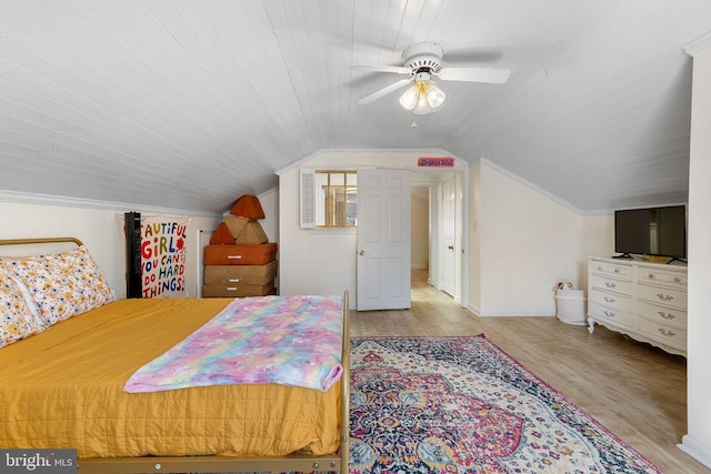 bedroom featuring a ceiling fan, lofted ceiling, wood finished floors, and baseboards