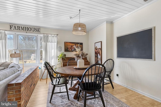 dining area with light wood-type flooring, baseboards, visible vents, and ornamental molding