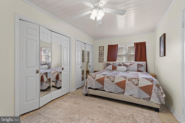 bedroom with a ceiling fan, two closets, wood finished floors, and crown molding