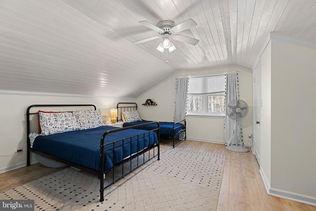 bedroom with wood finished floors, baseboards, lofted ceiling, ceiling fan, and crown molding