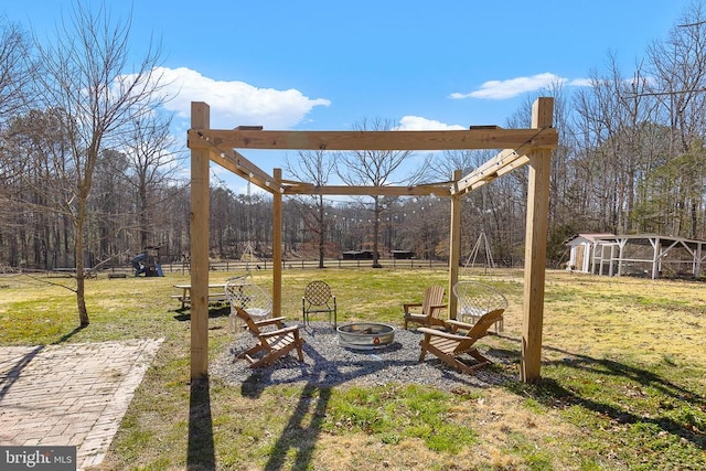 view of yard featuring an outbuilding, a fire pit, and fence