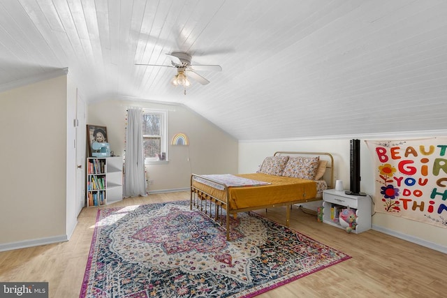 bedroom featuring lofted ceiling, wood finished floors, and baseboards