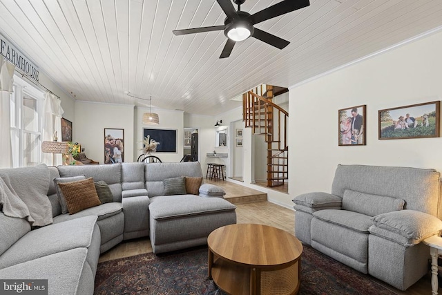 living room with a ceiling fan, wood finished floors, stairway, crown molding, and wood ceiling