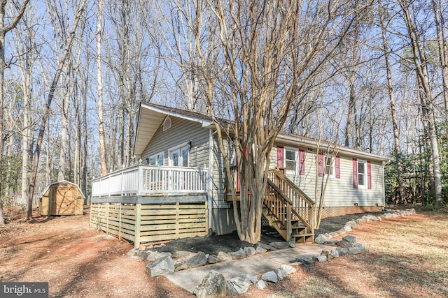 view of front of property with a deck, a storage unit, and an outdoor structure