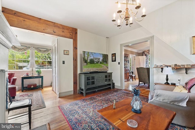 living room featuring a notable chandelier, beam ceiling, and light hardwood / wood-style flooring