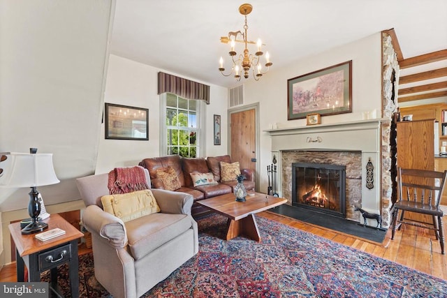 living room featuring wood-type flooring, a fireplace, and a notable chandelier