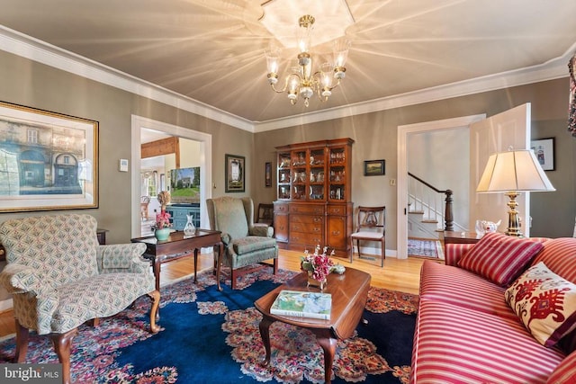 living room with hardwood / wood-style flooring, ornamental molding, and a notable chandelier