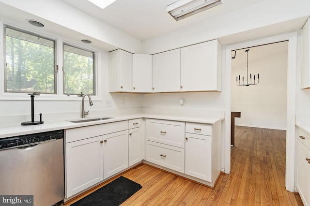 kitchen featuring white cabinetry, sink, stainless steel dishwasher, and light hardwood / wood-style floors