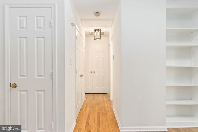 hall featuring light hardwood / wood-style flooring and built in features