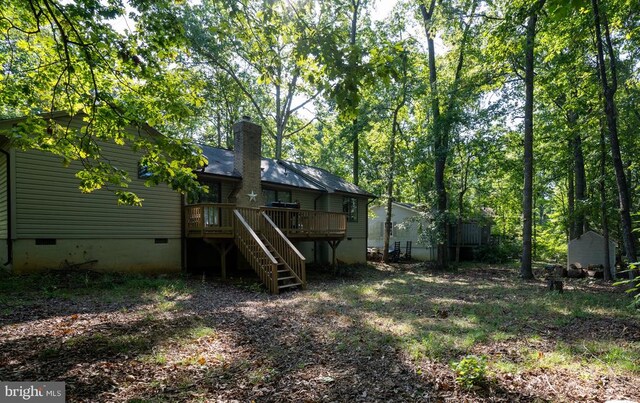 rear view of property featuring a wooden deck