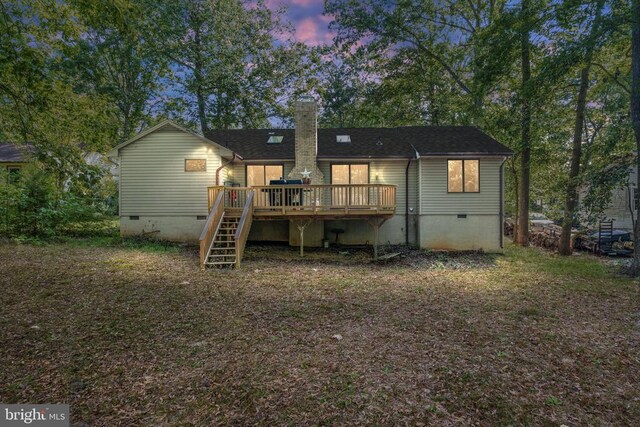 back house at dusk with a deck