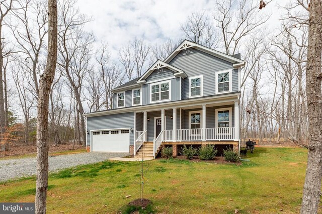 view of front facade featuring a front yard, a porch, driveway, and an attached garage