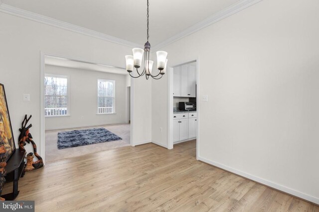 dining room featuring crown molding, baseboards, light wood-style flooring, and a notable chandelier