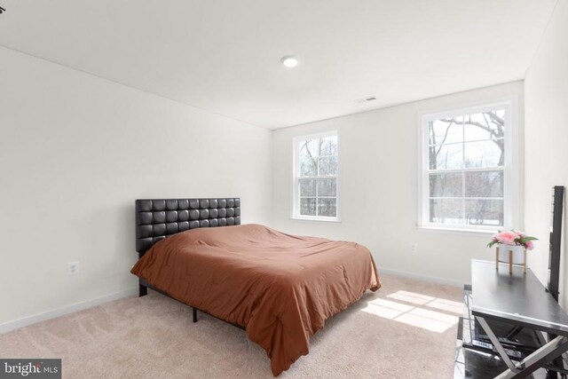 bedroom with light carpet and baseboards