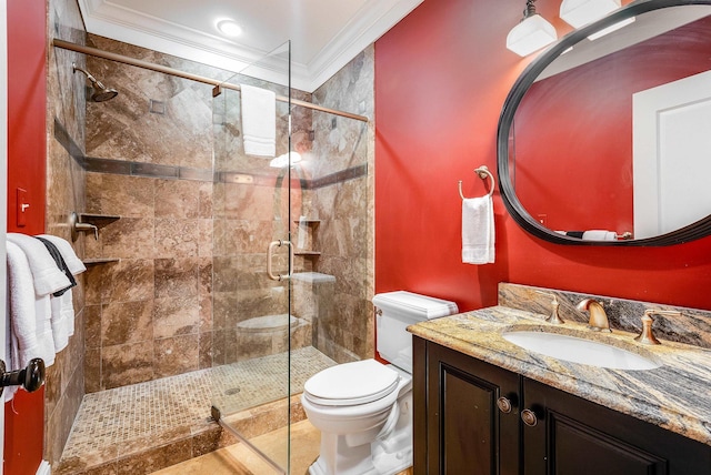 bathroom with vanity, crown molding, a shower with door, and toilet