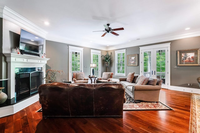 living room featuring wood-type flooring, ceiling fan, a fireplace, and french doors