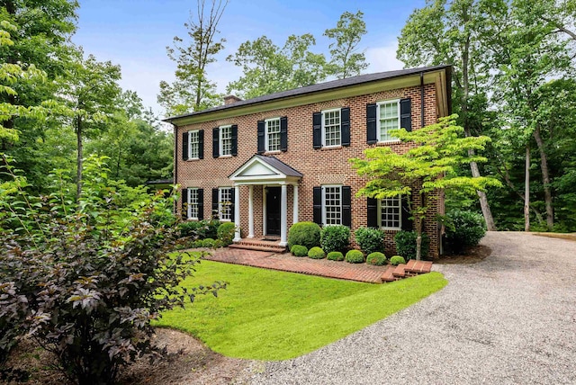 colonial home featuring a front lawn