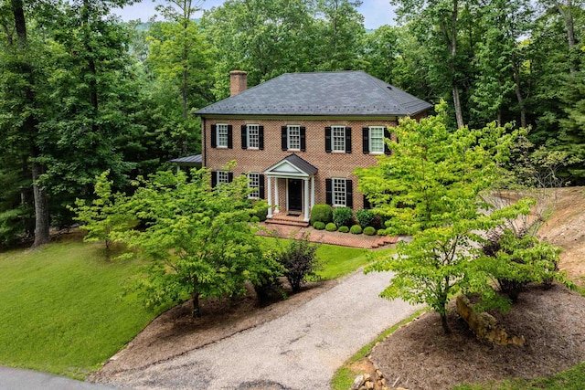 colonial-style house featuring a front yard