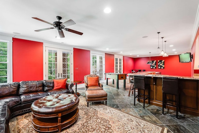 living room with french doors, bar, plenty of natural light, and ornamental molding