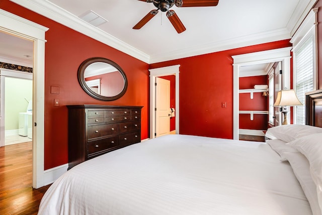 bedroom featuring crown molding, dark wood-type flooring, and ceiling fan