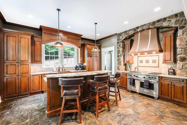 kitchen featuring light stone counters, wall chimney range hood, double oven range, and a center island