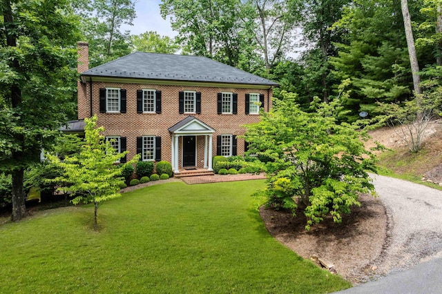 colonial inspired home with a front lawn