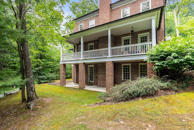 rear view of house featuring a lawn and a patio area