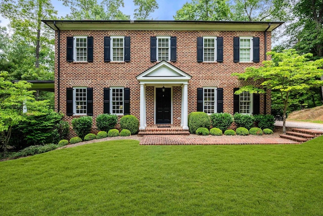 colonial-style house featuring a front yard