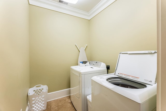 washroom featuring crown molding, washing machine and clothes dryer, and light tile patterned flooring