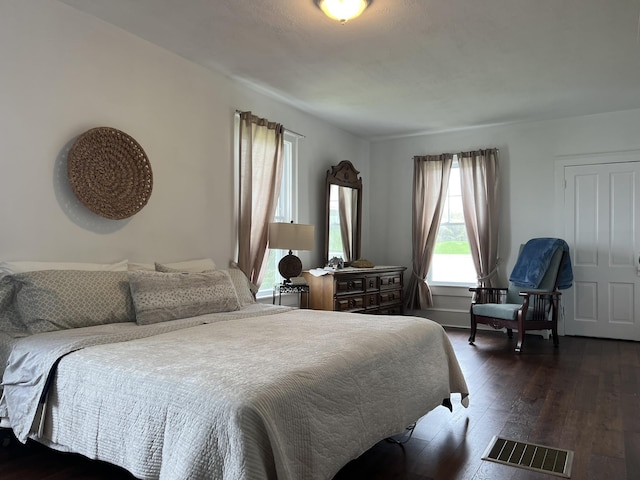 bedroom with dark hardwood / wood-style floors