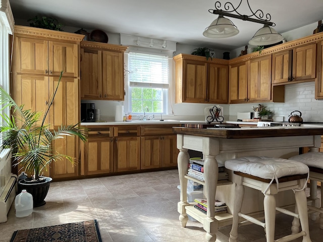 kitchen with pendant lighting, backsplash, a breakfast bar area, and sink