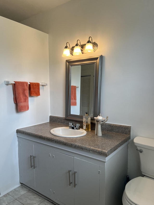 bathroom with tile patterned flooring, vanity, and toilet