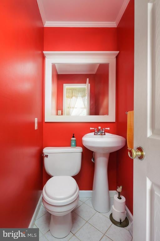 bathroom featuring tile patterned flooring, crown molding, sink, and toilet