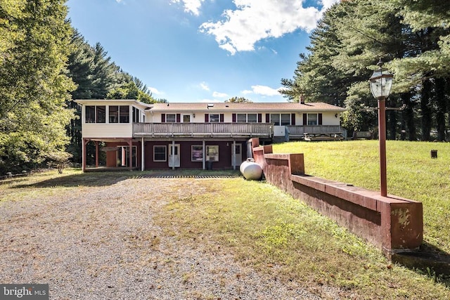 view of front of house with a front lawn, a sunroom, and a wooden deck