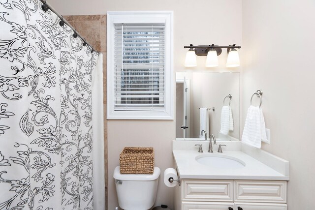 bathroom with vanity, curtained shower, and toilet