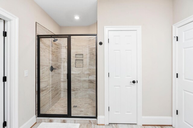 bathroom featuring a shower with door