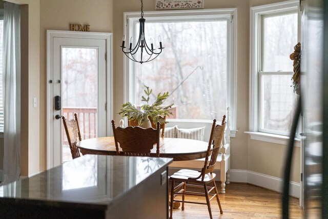 dining area with light hardwood / wood-style floors and a notable chandelier