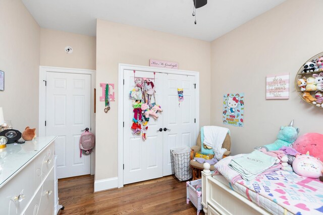 bedroom featuring a closet, dark hardwood / wood-style floors, and ceiling fan