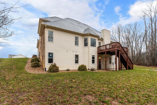 back of house with a deck and a lawn