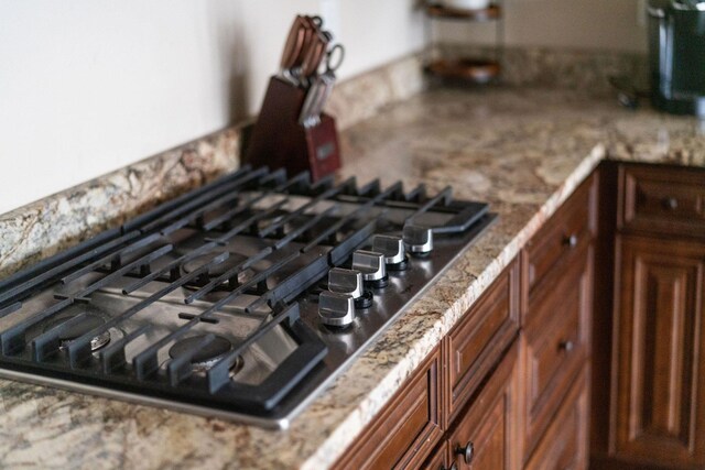 details with stone countertops and black gas cooktop