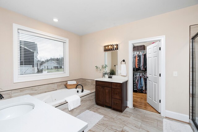 bathroom featuring vanity and independent shower and bath