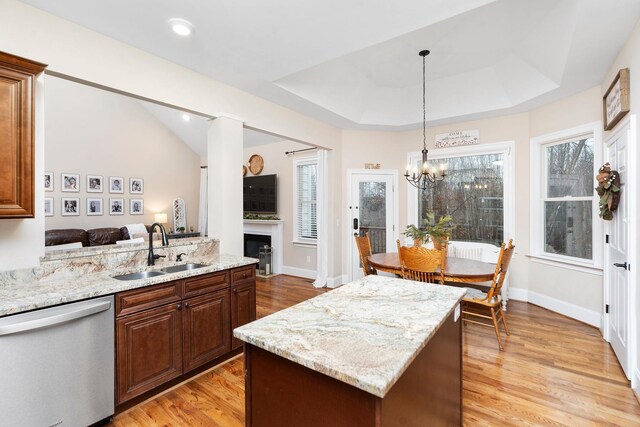 kitchen featuring sink, a tray ceiling, light hardwood / wood-style flooring, and dishwasher