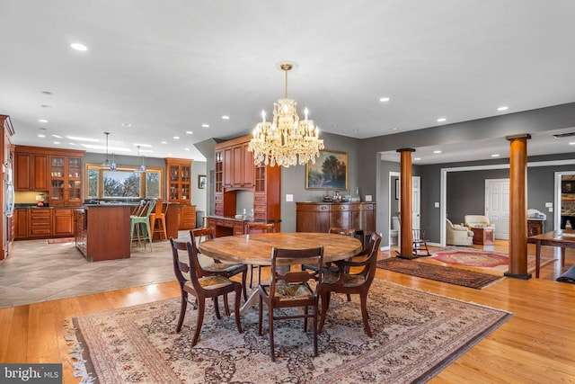 dining area with light wood finished floors, decorative columns, and recessed lighting